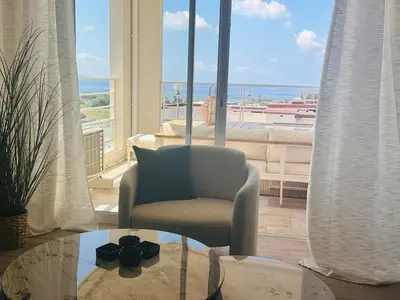 a living room with a chair and a glass table at Bleu Corse, entre mer et soleil in Ajaccio