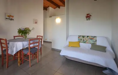 a room with a table and a bed and a table and chairs at Appartement Residence Piscine in Venzolasca