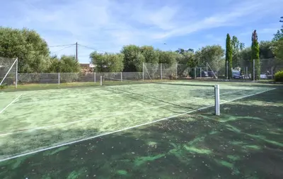 a tennis court with a net on top of it at Appartement Residence Piscine in Venzolasca