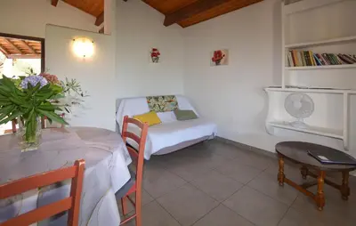a small room with a bed and a table with a tableablish at Appartement Residence Piscine in Venzolasca