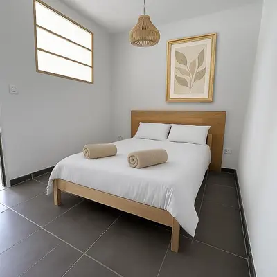 a bedroom with a white bed with two pillows on it at Maison Dolce Vita in Ghisonaccia