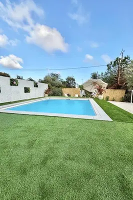 a swimming pool in a yard with green grass at Maison Dolce Vita in Ghisonaccia