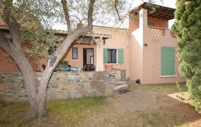 a house with a stone wall and a tree at Maison Residence Piscine in Venzolasca