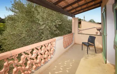 a balcony of a house with a chair at Maison Residence Piscine in Venzolasca
