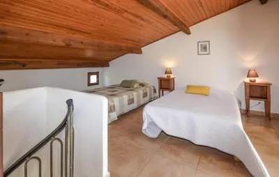 a bedroom with two beds in a room with wooden ceilings at Maison Residence Piscine in Venzolasca