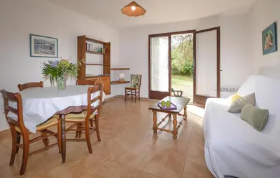 a living room with a table and a couch at Maison Residence Piscine in Venzolasca