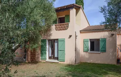 a house with green shutters and a tree at Maison Residence Piscine in Venzolasca
