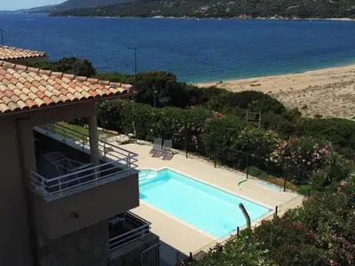 a house with a swimming pool next to a beach at T3 - bord de mer - piscine - vue magnifique in Propriano