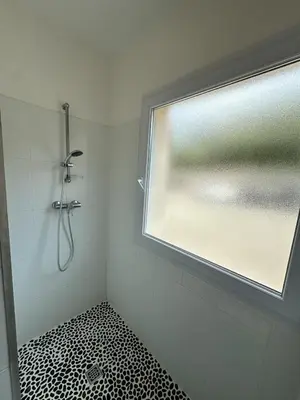 a bathroom with a shower and a window at T3 - bord de mer - piscine - vue magnifique in Propriano