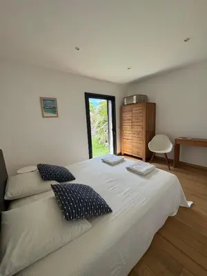 a bedroom with a large white bed with two pillows at VILLA Corse du Sud in Pianottoli-Caldarello