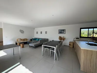 a kitchen and living room with a table and a couch at VILLA Corse du Sud in Pianottoli-Caldarello