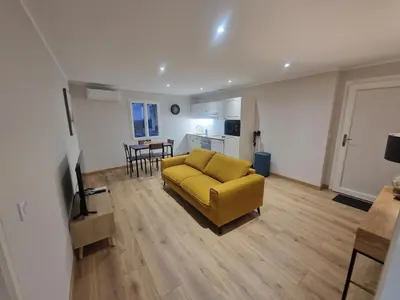 a living room with a yellow couch and a kitchen at appartement vezzani in Vezzani