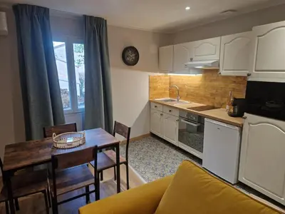 a kitchen and living room with a table and a couch at appartement vezzani in Vezzani