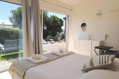 a bedroom with a bed and a large window at Villa U Serenu - Piscine, Jacuzzi & Vue Mer in Bonifacio