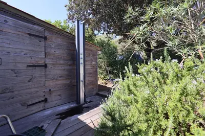 a pivot door on the side of a wooden wall at Villa U Serenu - Piscine, Jacuzzi & Vue Mer in Bonifacio