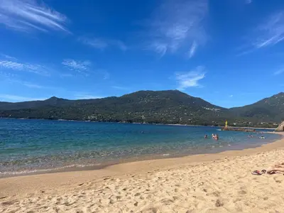 a beach with people swimming in the water at Bel appartement pied dans l'eau PROPRIANO in Propriano