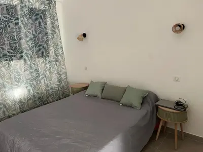 a bedroom with a bed with two tables and a window at Bel appartement pied dans l'eau PROPRIANO in Propriano