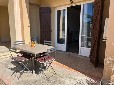 a table and two chairs in front of a door at Bel appartement pied dans l'eau PROPRIANO in Propriano