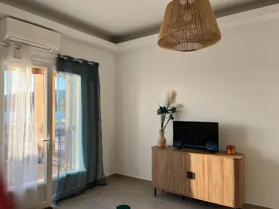 a living room with a tv and a window at Bel appartement pied dans l'eau PROPRIANO in Propriano