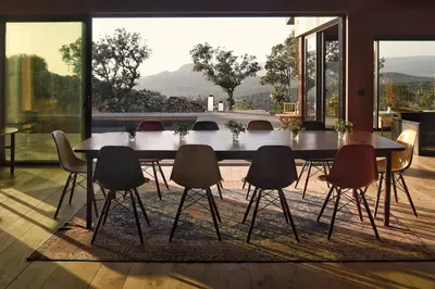 a dining room with a table and chairs on a rug at Lenza Barn Villa by Boutique Scenic Corsica in Pianottoli-Caldarello