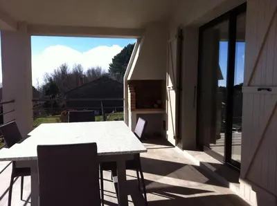 a table and chairs on a patio with a view at Entre mer et montagne Villa Cartalavonu in Porto-Vecchio
