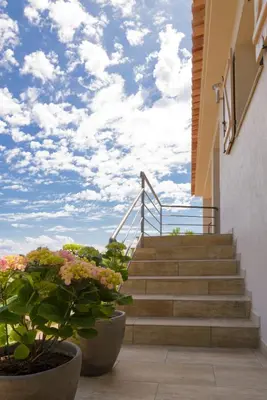 a set of stairs with a blue sky and clouds at Entre mer et montagne Villa Cartalavonu in Porto-Vecchio