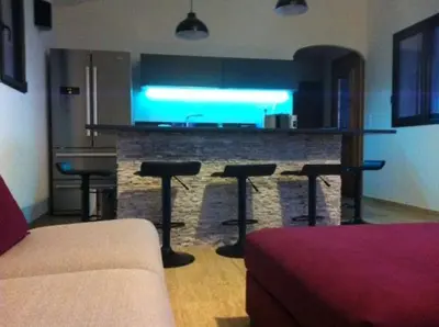 a kitchen with a bar with two stools and a counter at Entre mer et montagne Villa Cartalavonu in Porto-Vecchio