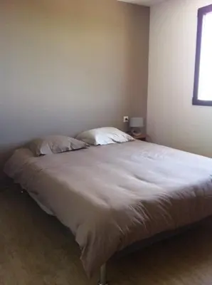 a bed with two pillows in a bedroom at Entre mer et montagne Villa Cartalavonu in Porto-Vecchio