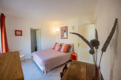 a bedroom with a bed and a table in a room at Villa de Charme avec Piscine et vue Mer en Corse du Sud in Propriano