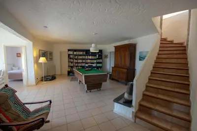 a living room with a pool table and stairs at Villa de Charme avec Piscine et vue Mer en Corse du Sud in Propriano