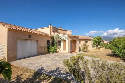 a large house with a garage in a yard at Villa de Charme avec Piscine et vue Mer en Corse du Sud in Propriano