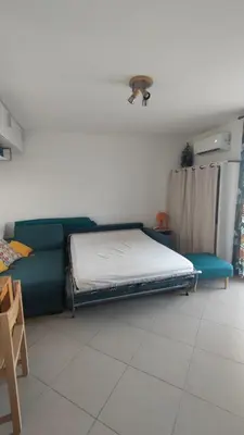 a bedroom with a bed and a couch and a table at Moriani-Plage 1-bedroom apartment in San-Nicolao