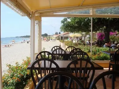 a table and chairs on a beach with the ocean at Moriani-Plage 1-bedroom apartment in San-Nicolao