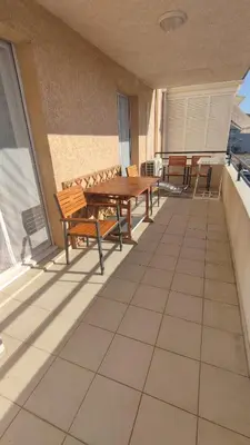 a patio with benches and a table on a balcony at Moriani-Plage 1-bedroom apartment in San-Nicolao