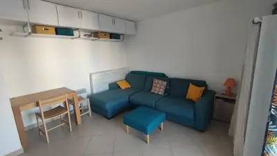a living room with a blue couch and a table at Moriani-Plage 1-bedroom apartment in San-Nicolao