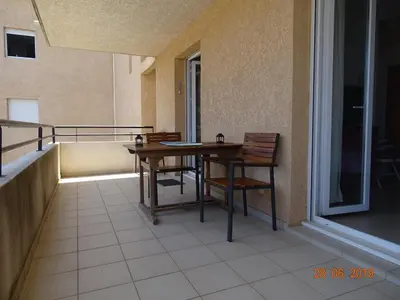 a balcony with a table and chairs on a balcony at Moriani-Plage 1-bedroom apartment in San-Nicolao