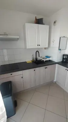 a kitchen with white cabinets and a black counter top at Moriani-Plage 1-bedroom apartment in San-Nicolao