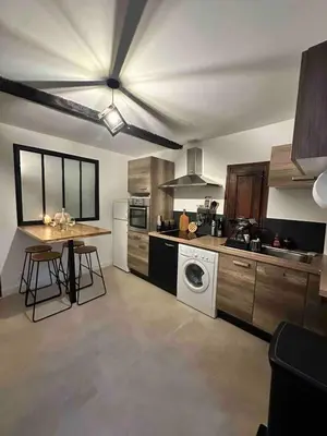 a kitchen with a washer and a table in it at studio au cœur de la vieille ville in Ajaccio