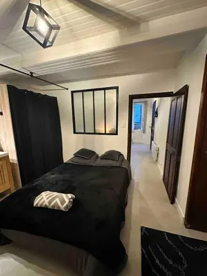 a bedroom with a large black bed and a window at studio au cœur de la vieille ville in Ajaccio