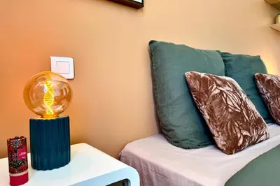 a lamp on a table next to a couch with pillows at Comfortable Villa with Pool Near Cala Rossa & Pinarello Beaches in Porto-Vecchio