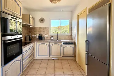 a kitchen with a sink and a refrigerator at Comfortable Villa with Pool Near Cala Rossa & Pinarello Beaches in Porto-Vecchio