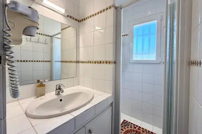 a white bathroom with a sink and a mirror at Comfortable Villa with Pool Near Cala Rossa & Pinarello Beaches in Porto-Vecchio