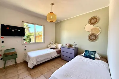 a bedroom with two beds and a window at Comfortable Villa with Pool Near Cala Rossa & Pinarello Beaches in Porto-Vecchio