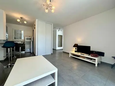 a living room with a white table and a television at Moriani-Plage in Santa-Lucia-di-Moriani