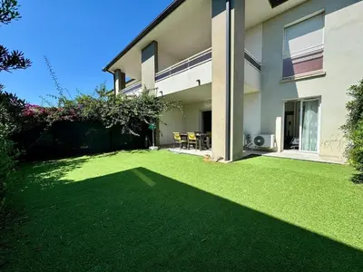 a large yard with a house with a green lawn at Moriani-Plage in Santa-Lucia-di-Moriani