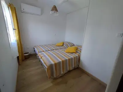 a small bedroom with a bed with yellow pillows at Villa bord de mer Résidence Alba Serena in Poggio-Mezzana