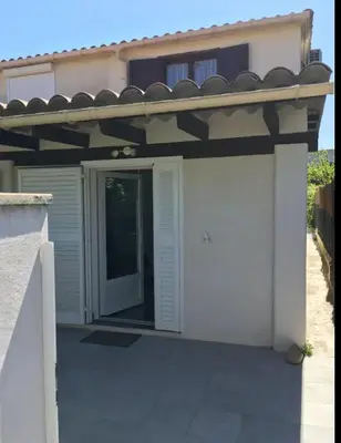 a white garage with a door and a roof at Villa bord de mer Résidence Alba Serena in Poggio-Mezzana