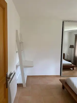 a bedroom with a staircase and a mirror and a bed at Sartène à pied in Sartène