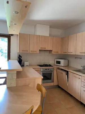 a kitchen with wooden cabinets and a stove top oven at Sartène à pied in Sartène