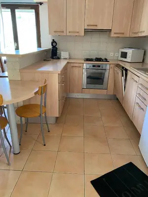 a kitchen with wooden cabinets and a table and a stove at Sartène à pied in Sartène